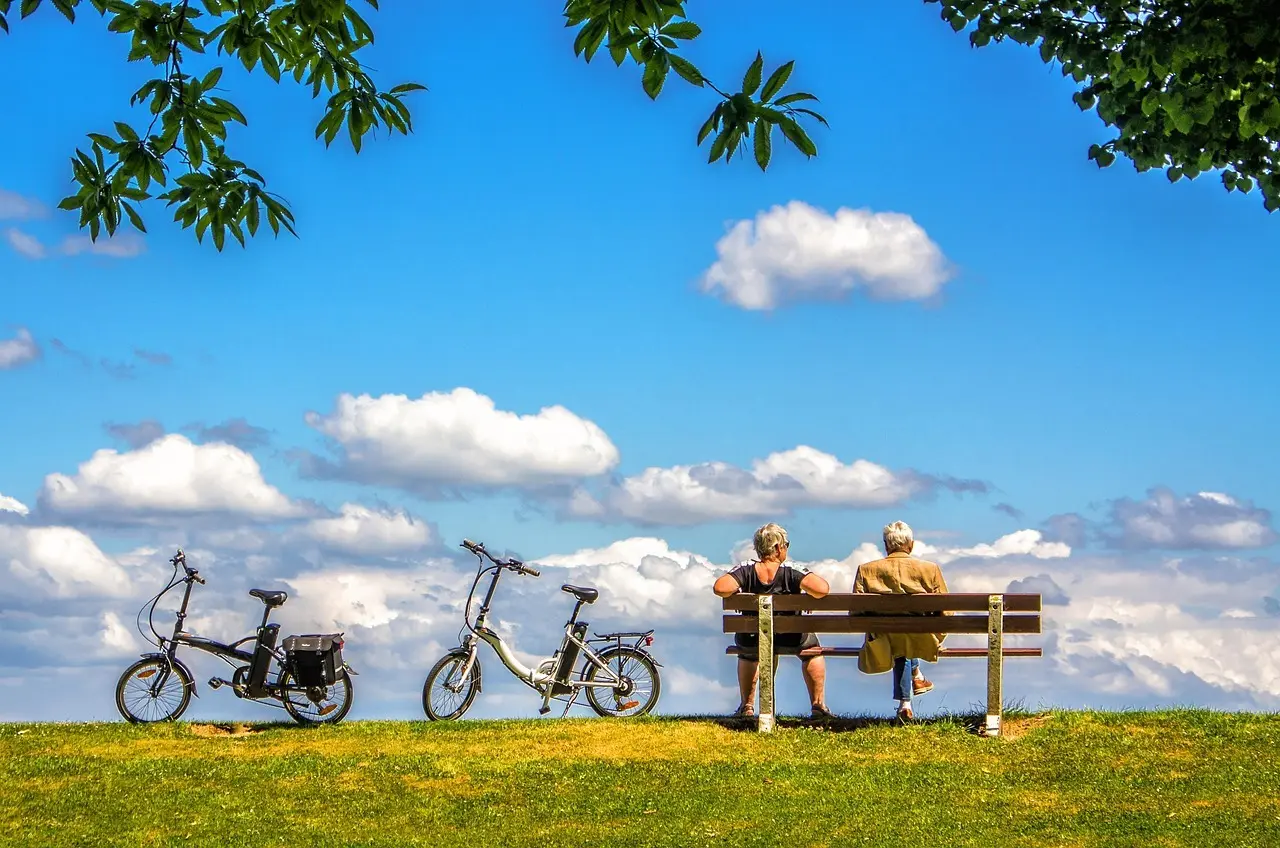 To mennesker holder pause ved deres cykler under en blå himmel.